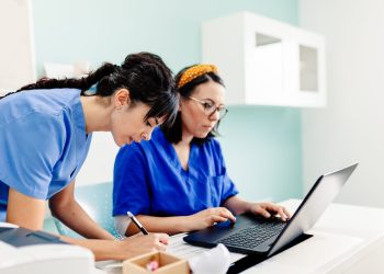 Female doctor and nurse using the laptop in the clinic