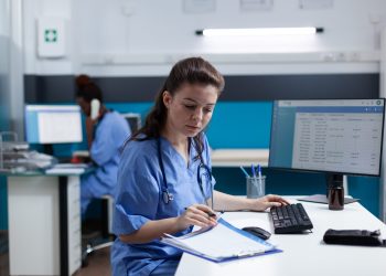 Pharmacist nurse with stethoscope analyzing healthcare treatment on medical documents typing sickness expertise working in hospital examination office. Woman asisstance checking disease results